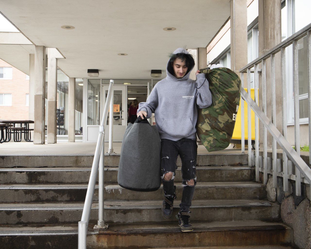 Freshman, Noah Emmer, takes some of his belongings out of Harrison Hall.